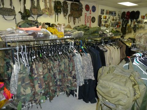 1992 Ford Mustang - A store interior filled with military-style clothing and gear, including camouflage jackets and backpacks.