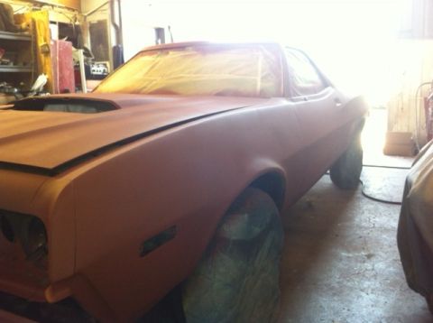 1972 Ford Ranchero - A 1972 Ford Ranchero is prepped for paint in a workshop, showing its distinctive hood scoop and body lines.