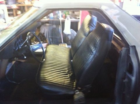 1972 Ford Ranchero - The interior of a 1972 Ford Ranchero shows a striped bench seat and the dashboard with steering wheel.