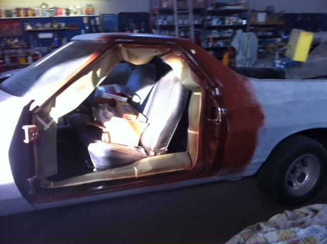 1972 Ford Ranchero in a workshop, primer on the rear quarter panel, interior visible