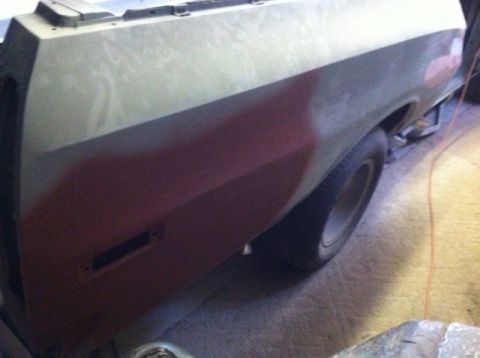 1972 Ford Ranchero - The rear quarter panel of a 1972 Ford Ranchero shows primer and red paint, indicating bodywork in progress.
