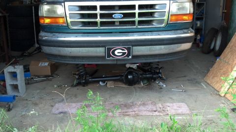 1996 Ford F-150 - Front axle removed from a 1996 Ford F-150, parked in a garage.