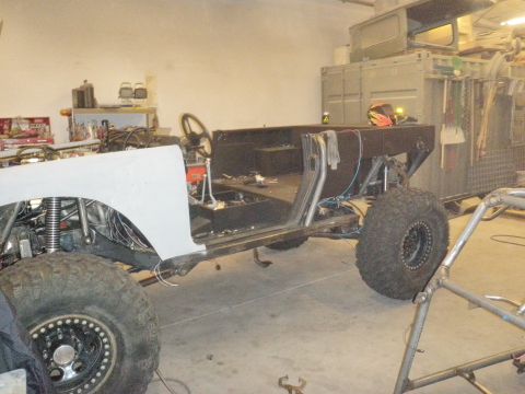 1961 International Scout 800 - This custom off-road vehicle chassis is undergoing modifications, large tires and a visible roll cage structure.