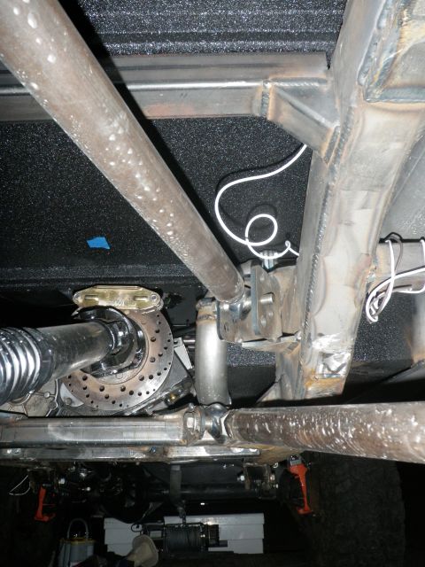 1961 International Scout 800 - Close-up view of the undercarriage, focusing on the exhaust system and suspension components.