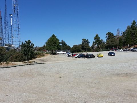 1995 Ford Taurus - A scenic view of a parking area with multiple vehicles and communication towers under a clear blue sky.