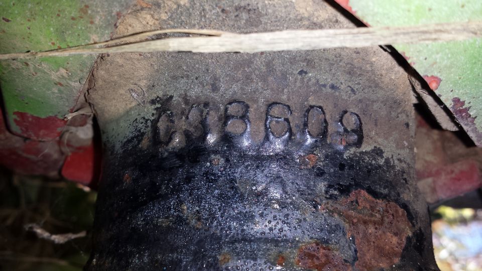 Stamped number C3B609 on a dirty black cast part under a 1979 Ford F-350
