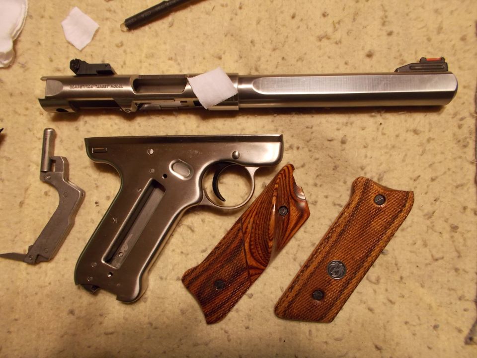 Disassembled handgun with wooden grips and frame laid out
