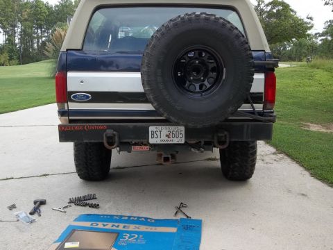 1995 Ford Bronco - Tools and a TV box are laid out on the driveway next to a Ford Bronco.