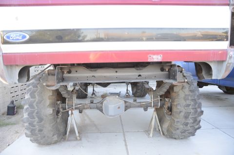 1979 Ford Bronco - Rear axle and suspension parts of a Ford truck are visible, with another vehicle in the background.