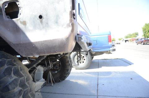 1979 Ford Bronco - The rear of a vehicle is shown on jack stands, with another vehicle parked behind it.