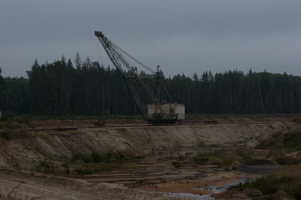 Dragline excavator in a quarry with a forest background