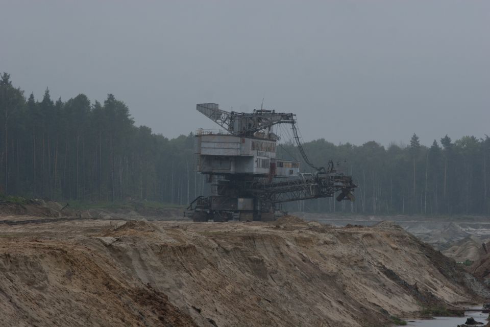 Bucket-wheel excavator in a quarry with a forest in the background