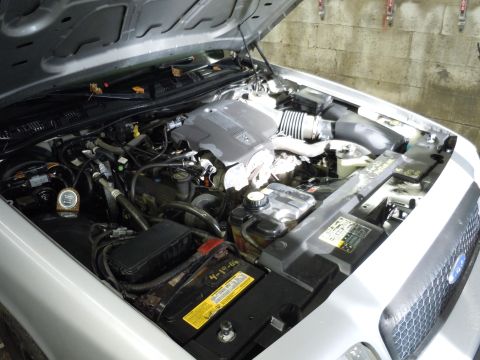 2001 Ford Crown Victoria - The engine bay of a 2001 Ford Crown Victoria is visible with the hood raised.