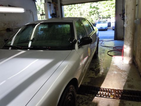 2001 Ford Crown Victoria - A white sedan is partially visible in a garage, with another white vehicle in the background.