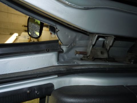 2001 Ford Crown Victoria - Close-up view of a car's interior door frame, showing structural details and a side mirror reflection.