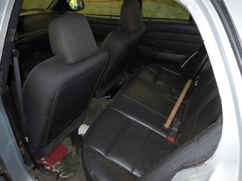2001 Ford Crown Victoria - The interior rear seats of a 2001 Ford Crown Victoria show black upholstery and a view of the door panel.