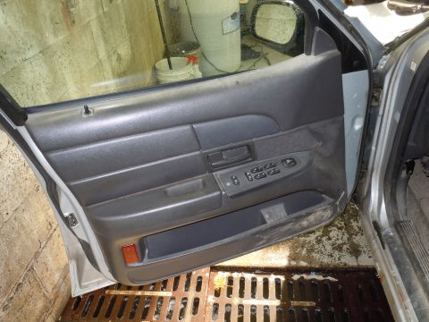 2001 Ford Crown Victoria - The interior door panel of a 2001 Ford Crown Victoria is visible, with power window controls and a storage pocket.