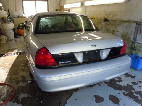 2001 Ford Crown Victoria - The rear of a silver Ford Crown Victoria Police Interceptor is shown in a garage setting.