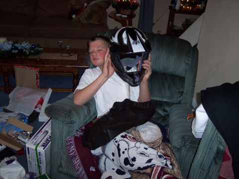 1990 Ford Bronco - A young boy sits in a recliner, holding a motocross helmet, surrounded by Christmas decorations and gifts.