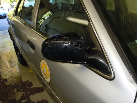 2001 Ford Crown Victoria - Side view of a silver sedan, showing a damaged side mirror and a circular emblem on the driver's door.