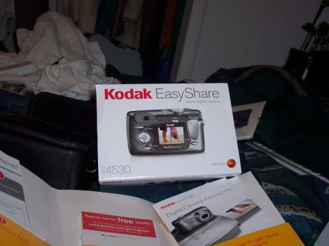 1990 Ford Bronco - Kodak EasyShare R4530 digital camera box and accessories are laid out on a bed.