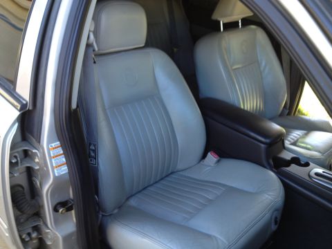1998 Ford Crown Victoria - The interior of a car shows gray leather seats with a center console and door panel visible.