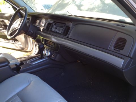 1998 Ford Crown Victoria - The interior of a 1998 Ford Crown Victoria is visible, including the dashboard and front seats.