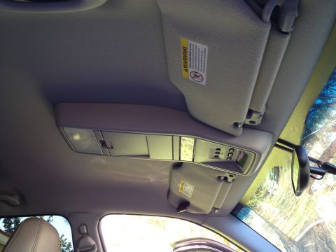 1998 Ford Crown Victoria - Interior view of a car's overhead console and sun visor, showing a warning label.