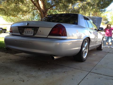 1998 Ford Crown Victoria - Rear view of a silver Mercury Marauder parked on a driveway with its hood up.