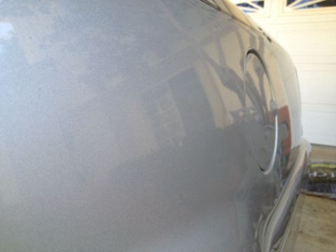 1998 Ford Crown Victoria - Close-up of the rear quarter panel of a silver car, showing the gas cap door.