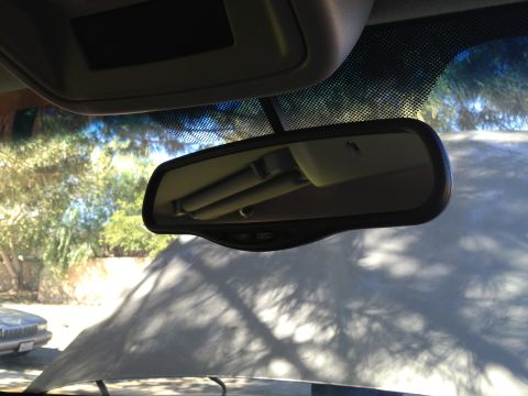 1998 Ford Crown Victoria - View from inside a vehicle, looking at the rearview mirror and windshield with another car visible through the windshield.