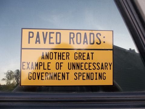 1995 Ford Bronco - Sticker on a vehicle window expresses a political opinion about government spending on roads.