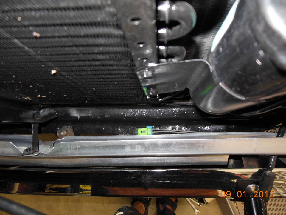 Close-up of vehicle radiator with hoses and electrical connector