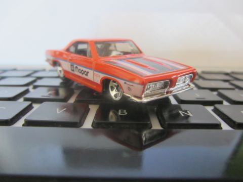 1968 Ford Mustang - A toy car with Mopar branding sits on a computer keyboard.