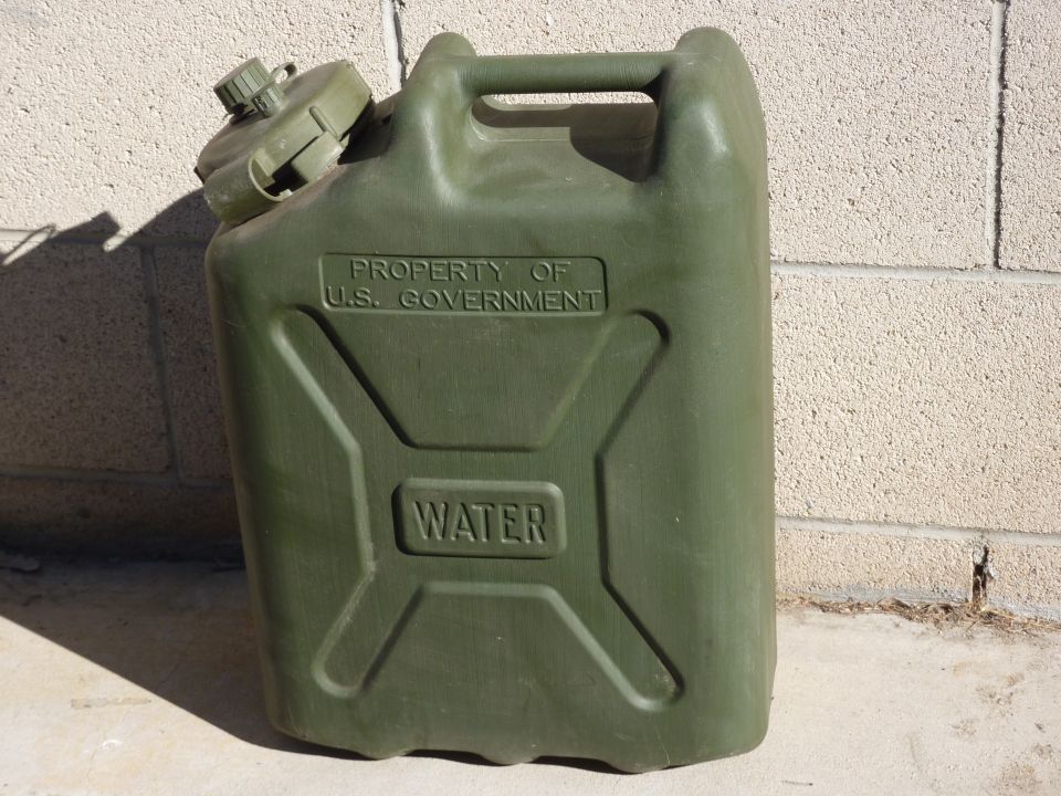 Green plastic water container with "PROPERTY OF U.S. GOVERNMENT" and "WATER" embossed on its side