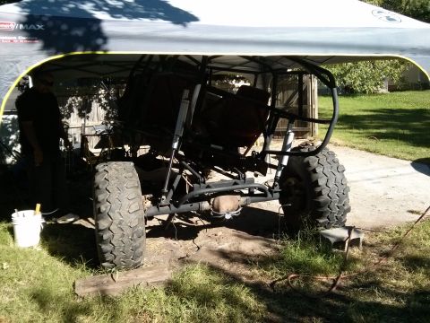 1986 Ford Bronco - Custom off-road buggy frame with large tires is partially covered by a canopy.