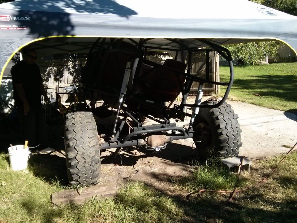 Off-road buggy frame with large tires, under a canopy
