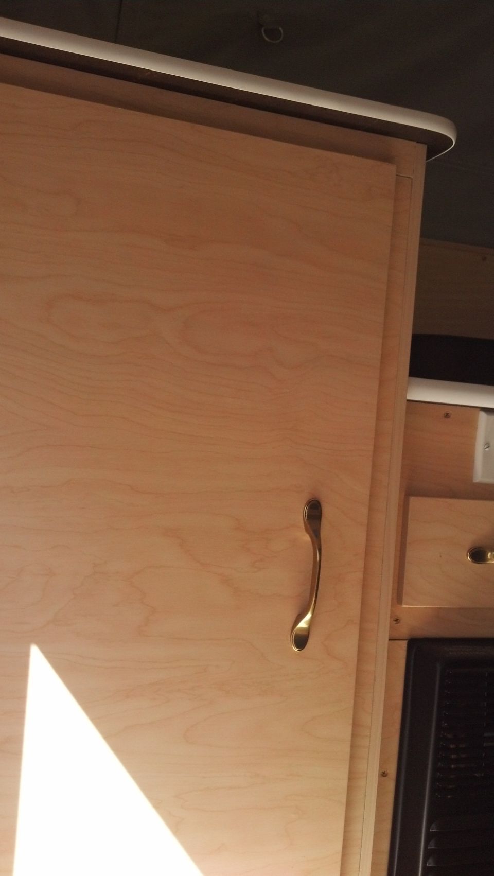 Interior camper cabinet with wooden door and brass handle