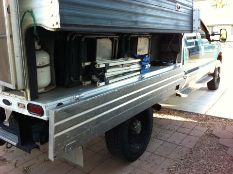 1999 Ford F-250 - Rear view of a 1999 Ford F-250 truck bed, loaded with camping gear and a camper shell.