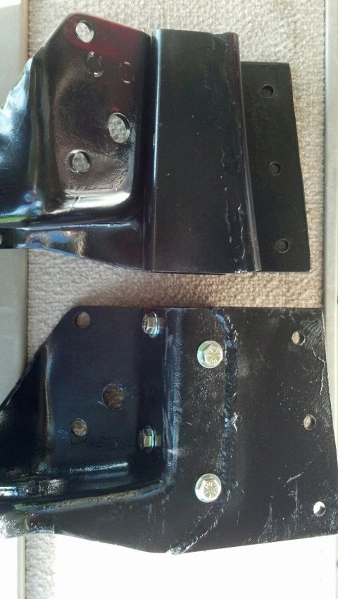1996 Ford F-150 - Two black metal brackets, likely for a truck frame, are shown close-up.