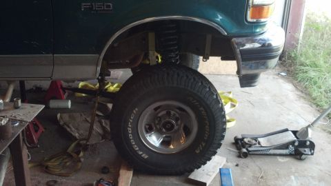1996 Ford F-150 - A green 1996 Ford F-150 is shown from the side, with its front wheel and fender area lifted on jack stands.