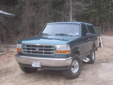 1996 Ford Bronco - This Ford Bronco is shown from a three-quarter front view, parked in an outdoor setting with trees visible.
