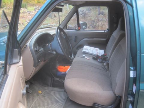 1996 Ford Bronco - Interior view of a green truck's cabin, showing the driver's side and bench seat.