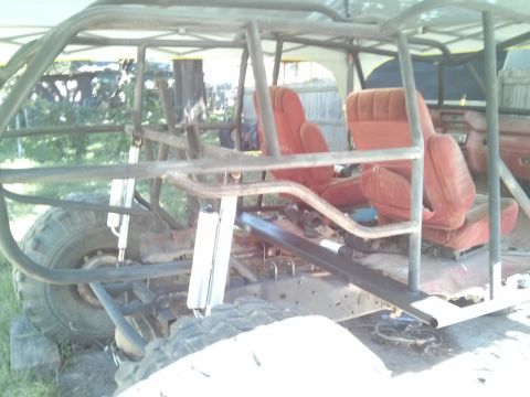 1986 Ford Bronco - This custom buggy features a robust roll cage and bright red interior seats, built for off-road adventures.