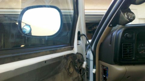 1997 Dodge 3500 - The interior of a truck shows exposed door panel components and a gauge mounted on the dashboard.