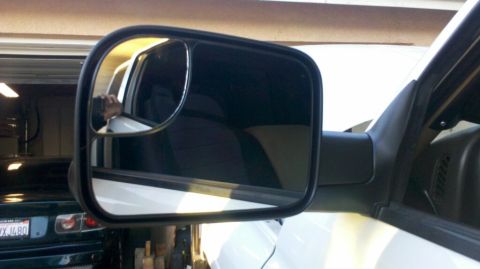 1997 Dodge 3500 - Close-up of a truck's side mirror, showing a reflection of the interior and another vehicle in the background.