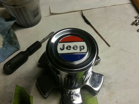 1982 Jeep Wagoneer - A close-up of a Jeep emblem, likely for a vehicle part, with tools laid out nearby.
