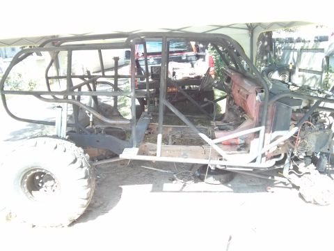 1986 Ford Bronco - This vehicle is undergoing a custom build, a prominent roll cage and large off-road tires.
