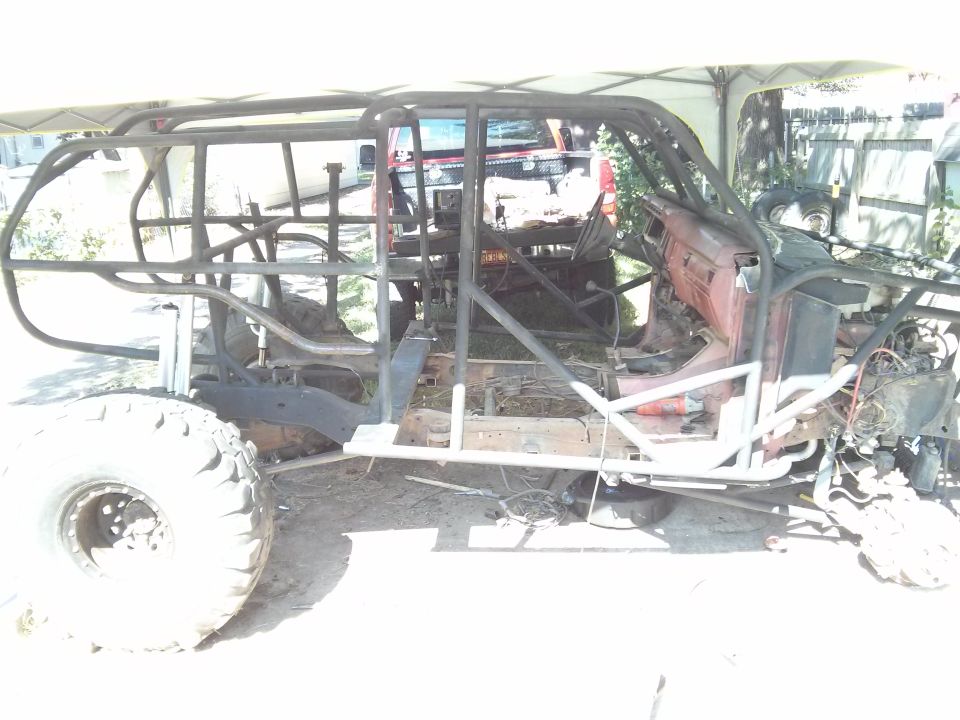 Custom off-road buggy build with a roll cage and large tires, appears to be a project in progress