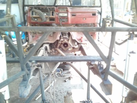 1986 Ford Bronco - The interior of a 1986 Ford Bronco is visible, a red dashboard and a prominent roll cage structure.